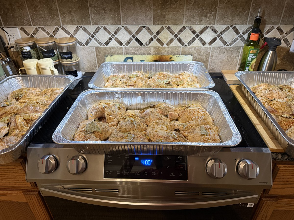 Large pans of seasoned herb chicken being prepped for 30 guests